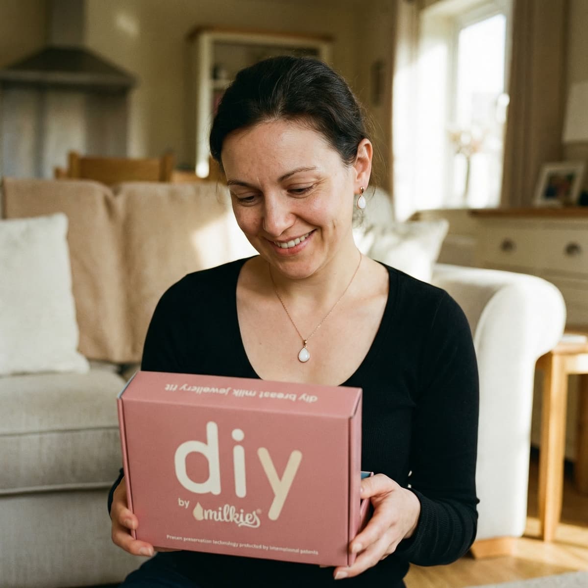 Glückliche Mutter hält das DIY by MILKIES Kit in den Händen – ideal, um zu Hause eine kette muttermilch als persönlichen Erinnerungs-Schmuck selbst herzustellen.