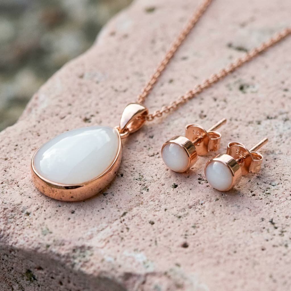 Roségoldfarbenes Schmuck-Set mit ovalem Anhänger und passenden Ohrsteckern mit milchig-weißem Einsatz – Beispiel für ein DIY Set Schmuck aus Muttermilch als persönliches Erinnerungsstück.